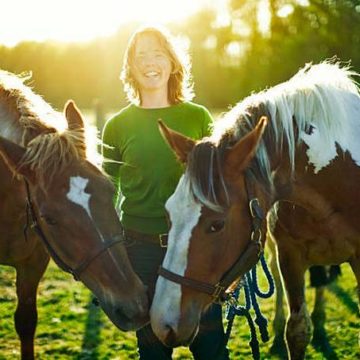 young-woman-with-horses-in-pasture