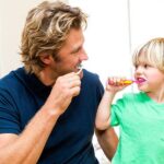 father-and-son-brushing-teeth-together