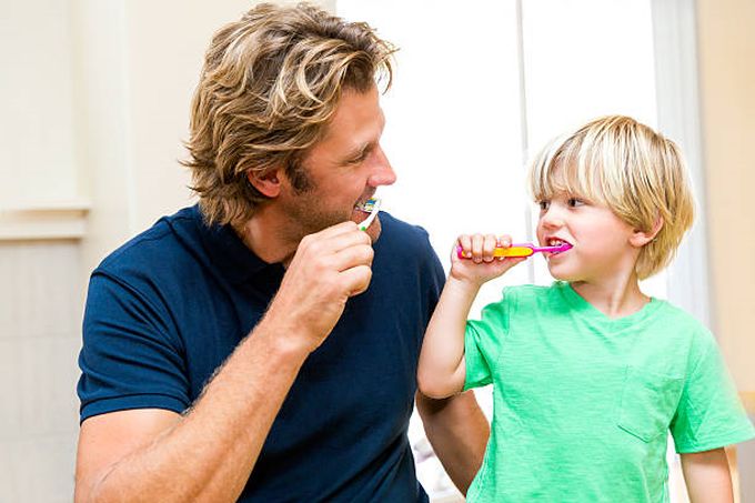 father-and-son-brushing-teeth-together
